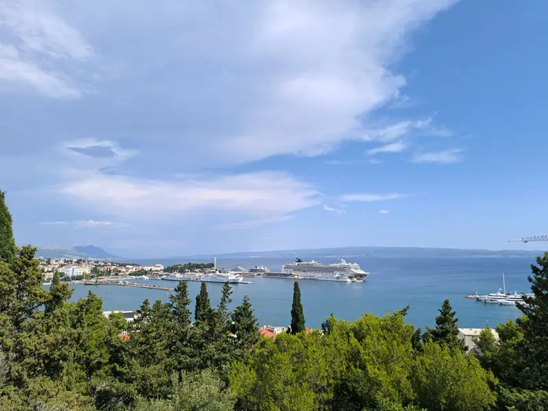 Beautiful panoramic view of Split harbor, Croatia, with cruise ships and lush greenery.