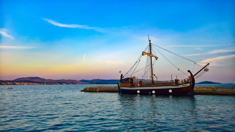 A beautifully preserved historic ship docked at sunset in a serene Croatian harbor.