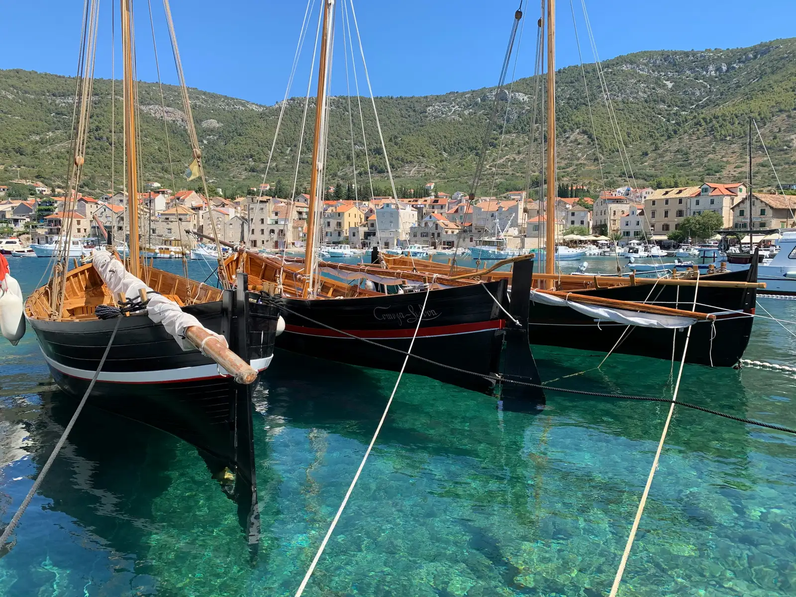 brown and white sail boat on blue water during daytime