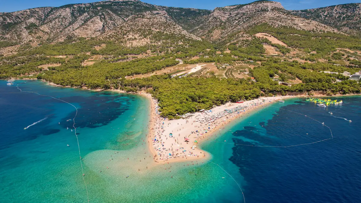 Stunning aerial view of Zlatni Rat Beach with turquoise waters and lush surroundings.